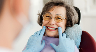 Dentist looking at smiling patient's teeth