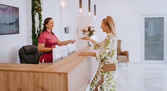 Dental receptionist assists client at desk